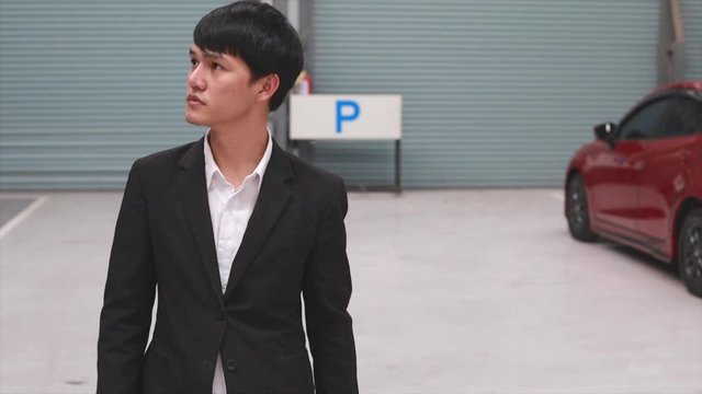 Asian man saleman walking to Checking Inspection period with car engine in showroom dealership.to automotive automobile or transport transportation video panning shot and people movement  4k clip
