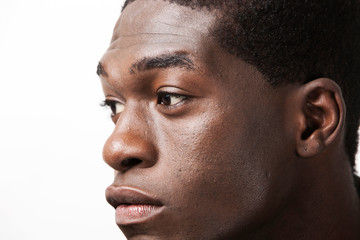 Close-up shot of thoughtful young man looking away against white background