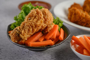 Crispy fried chicken on a plate with tomato sauce and carrot, Selective focus.