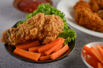 Crispy fried chicken on a plate with tomato sauce and carrot, Selective focus.