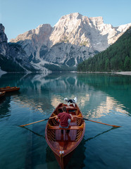man and dog in a boat on a mountain lake. Trip with a pet to Italy. Australian Shepherd Dog and its owner © Anna Averianova
