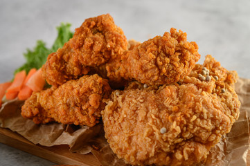 Crispy fried chicken on a wooden cutting board. Selective focus.