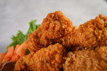 Crispy fried chicken on a wooden cutting board. Selective focus.
