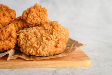 Crispy fried chicken on a wooden cutting board. Selective focus.