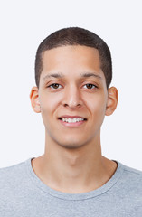 Portrait of young mixed race man smiling against white background