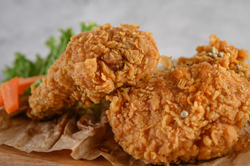 Crispy fried chicken on a wooden cutting board. Selective focus.