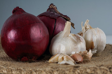 Selective focus.  Fresh onion and garlic over brown background.