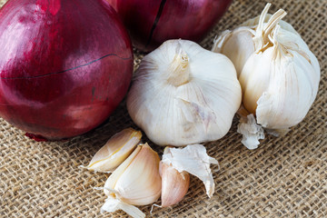 Selective focus.  Fresh onion and garlic over brown sack background.