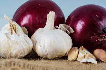 Selective focus.  Fresh onion and garlic over brown background.