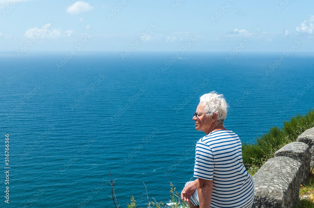 Wall mural woman traveler looking at the beautiful sea.