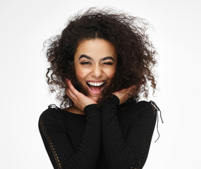Laughing latin american woman with afro hairstyle isolated on white background