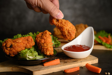 Hand holding crispy fried chicken.
