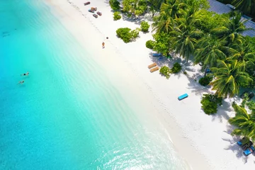 Fotobehang Beautiful white sandy beach with turquoise ocean water, waves and green fluffy palm trees, Aerial top view,  copy space. © Laura Pashkevich