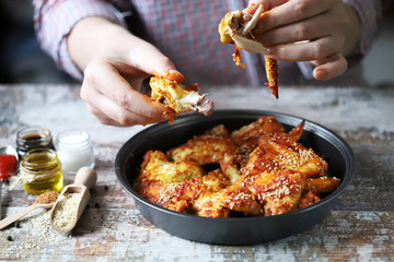 Selective focus. A man eats chicken wings with his hands. Chicken wings baked with sesame seeds. Buffalo Wings.
