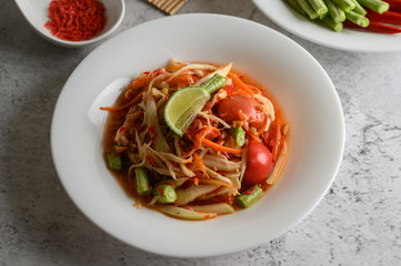 Thai papaya salad in a white plate