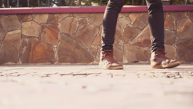 Unrecognizable men feets in sneakers is walking on tile road. Urban Environment. Cropped. Action. Animation. 4K.