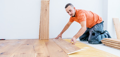 Handwerker verleget Parkett boden in einem modernen neubau Haus