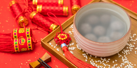 Naklejka na ściany i meble Chinese Lantern Festival traditional food black sesame dumplings on red background