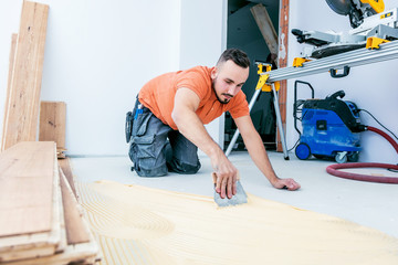 Handwerker verleget Parkett boden in einem modernen neubau Haus