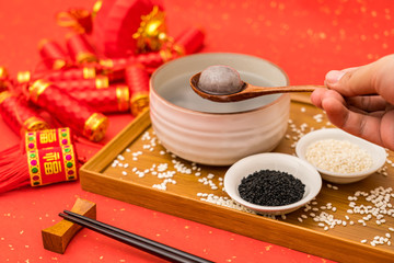 Chinese Lantern Festival traditional food black sesame dumplings on red background