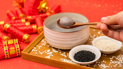 Chinese Lantern Festival traditional food black sesame dumplings on red background
