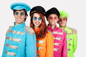 Portrait of young marching band members in colorful clothing against gray background