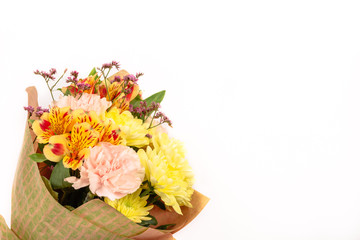 bouquet of pink ghoek, yellow chrysanthemum and Alstroemeria packed in paper isolated on a white background