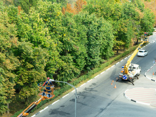 The specialist performs work on replacing old lamps on lampposts with new led lamps.