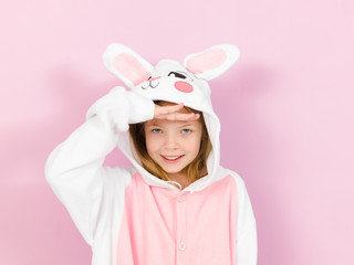 pretty blonde girl with cozy rabbit costume is posing in the studio and is happy