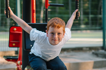 A boy on public street simulators. Little boy playing sports