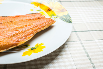 Good smoked coho fish in large plate on kitchen table.