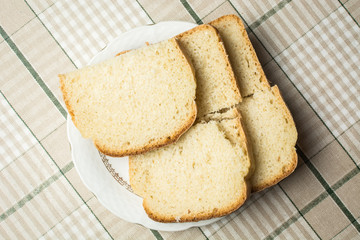 Sliced pieces of white bread in plate on kitchen table.