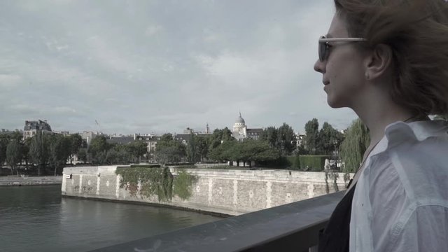 Attractive woman enjoying the view of a river on a windy day.