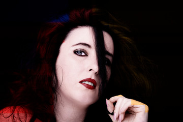 Fototapeta premium Young attractive woman with long black hair on dark background