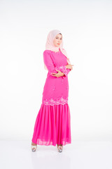 Beautiful female model wearing pink modern kurung, a modern urban lifestyle apparel for Muslim women isolated on white background. Beauty and hijab fashion concept.