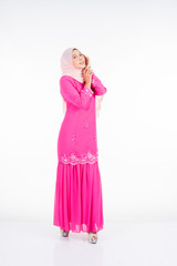 Beautiful female model wearing pink modern kurung, a modern urban lifestyle apparel for Muslim women isolated on white background. Beauty and hijab fashion concept.