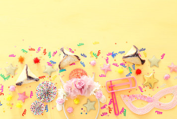 Purim celebration concept (jewish carnival holiday) over wooden table