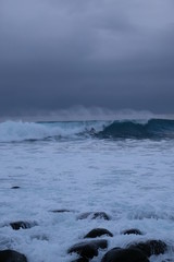 Surfer ride a wave in Unstad beach area which is known as an arctic surfing center located in Lofoten Islands in Northern Norway. 