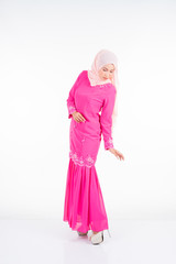 Beautiful female model wearing pink modern kurung, a modern urban lifestyle apparel for Muslim women isolated on white background. Beauty and hijab fashion concept.