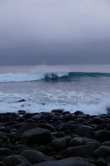 Surfer ride a wave in Unstad beach area which is known as an arctic surfing center located in Lofoten Islands in Northern Norway. 