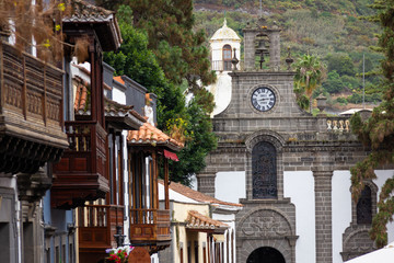 Terror street houses with traditional wooden balconies and Basilica of Virgen del Pino on...