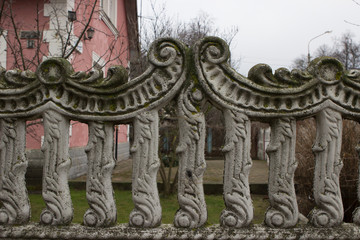 old gloomy vintage concrete fence of a private house overgrown with moss.