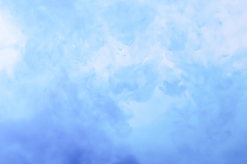 Close-up. The color is dissolving in the water, the background is blurred