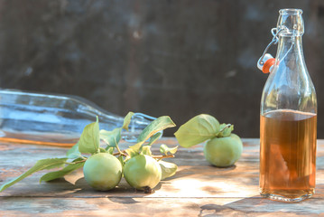 apple cider poured into bottles. Glasses filled with apple cider vinegar stand on an old vintage table. In warm colors. summer rest