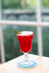 Close-up strawberry juice on a wooden table near the window