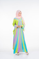 Beautiful female model wearing a pastel batik kaftan/caftan, a traditional dress for Muslim women isolated over white background. Stylish Muslim female hijab fashion lifestyle portraiture concept.