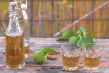 apple cider poured into bottles. Glasses filled with apple cider vinegar stand on an old vintage table. In warm colors. summer rest