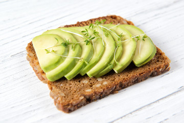 Whole wheat toast bread with sliced avocado with garden cress sprouts, healthy eating concept, close up