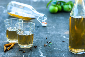 A close-up photo of an apple cider. Vintage glass bottles filled with apple cider vinegar, with...