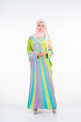 Beautiful female model wearing a pastel batik kaftan/caftan, a traditional dress for Muslim women isolated over white background. Stylish Muslim female hijab fashion lifestyle portraiture concept.